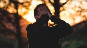 man in woods hands over face needs cognitive behavioural therapy